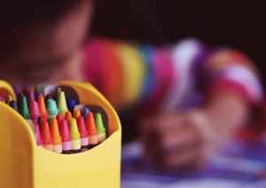 Child as desk with crayon box